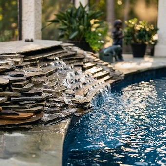 A dry-stacked stone waterfall spilling into a pool