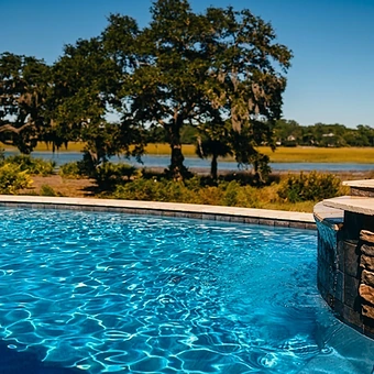 A pool under a live oak with the marsh beyond